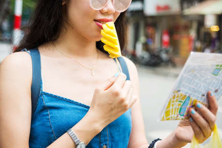 Happy tourist with pineapple slice on a stick on Asian trip