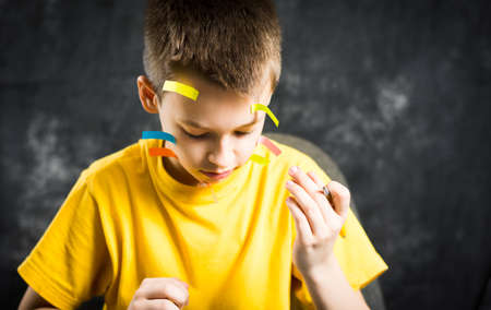 Teenage boy with his face covered in note stickersの写真素材
