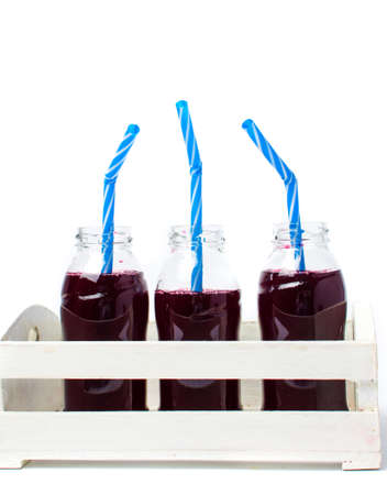 Blueberry juice bottles in a white wooden box isolatedの写真素材