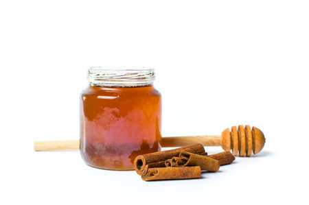 Jar of honey and cinnamon isolated on whiteの写真素材