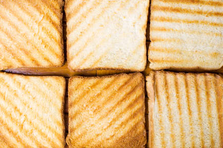 Toasted bread slices in golden color forming backgroundの写真素材