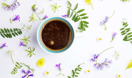 Cup of coffee and colorful flowers on white background