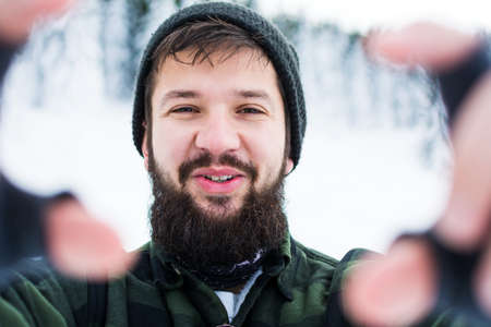 Bearded man taking selfie on snowy mountain close upの写真素材