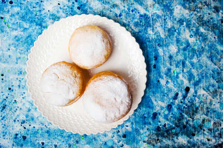 Homemade doughnuts covered with sugar powder on a plate