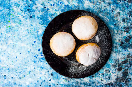 Homemade doughnuts covered with sugar powder on a plateの写真素材