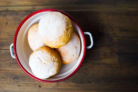 Homemade doughnuts covered with sugar powder on a plateの写真素材