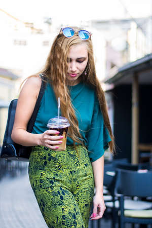 Urban girl with coffee to go on the streetの写真素材