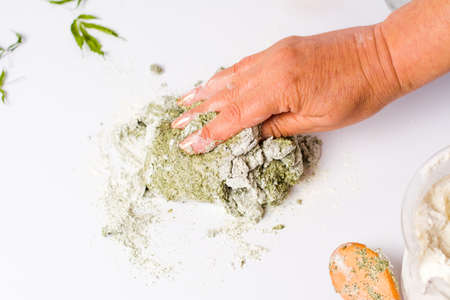 Woman kneading dough of mixed marijuana and wheat flour