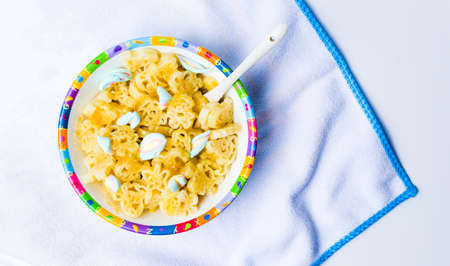 Shaped children pasta in colorful bowl tabletopの写真素材