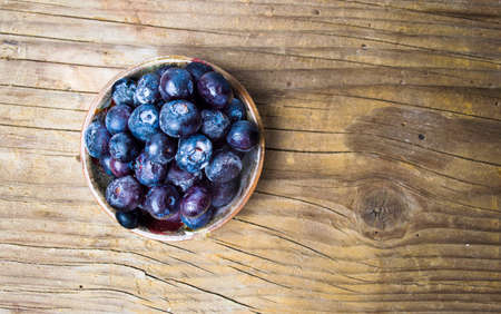 Blueberry fruit in a bowl on rustic wooden background