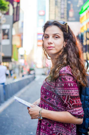 Female tourist with a map at Times Square in New York, USAの写真素材