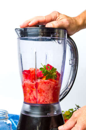 Man using blender to make a healthy tomato smoothieの写真素材