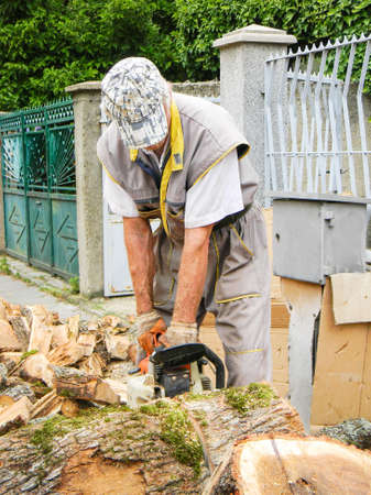 Man cutting big wood with a chainsawの写真素材