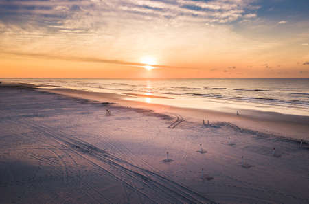Sunrise over the ocean and wide beach aerial viewの写真素材