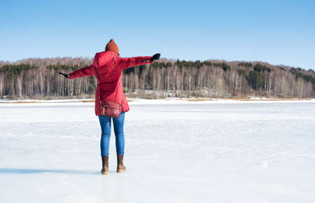 Girl having fun on a frozen lake on a sunny winter dayの写真素材