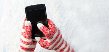 Hands using smart phone in winter glovesの写真素材