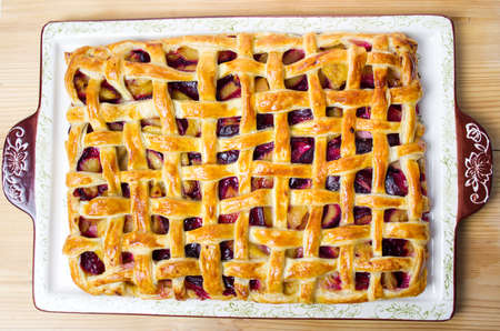 Sweet baked fruit pie with sugar on a trayの写真素材