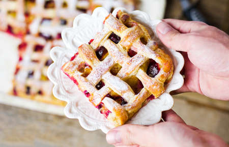 Woman serving sweet fruit pie slice on a plateの写真素材
