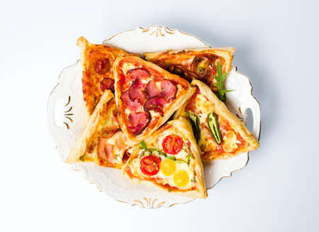 Various pizza sandwich pastries with vegetables on a plateの写真素材