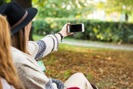 Two girlfriends taking selfie in the parkの写真素材