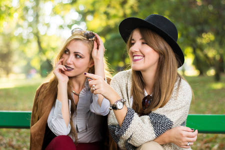 Female friends gossiping on a park bench