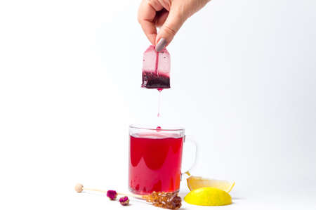 Hand taking out tea bag out of the glass isolatedの写真素材