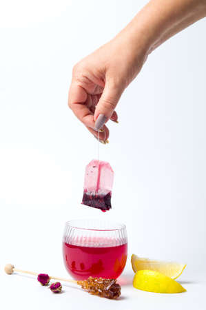 Hand taking out tea bag out of the glass isolatedの写真素材