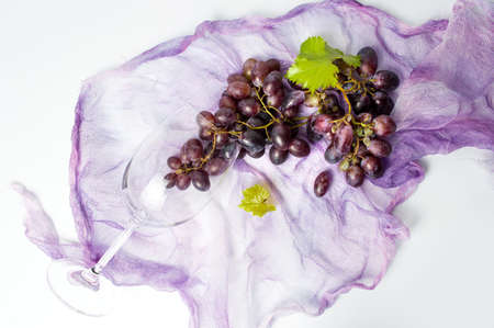 Fresh red grape in wine glass on whiteの写真素材