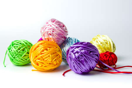 Colorful knitting thread balls on white table