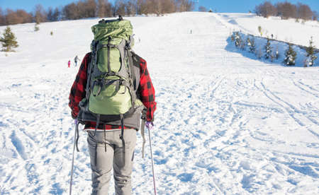 Male hiker with backpack on snow covered mountainの写真素材