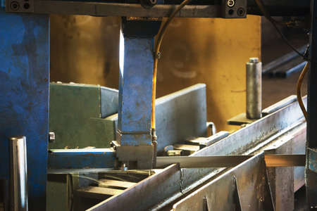 Automated saw cutting stainless steel cooled with waterの写真素材