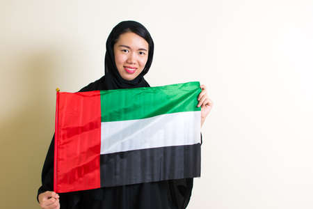 Muslim woman holding the United Arab Emirates flagの写真素材