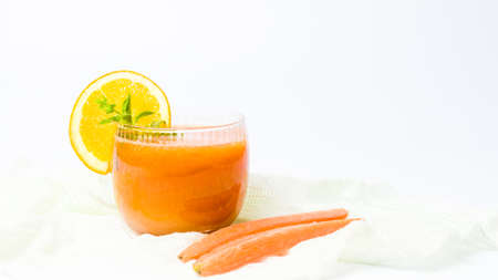 Healthy carrot and orange smoothie in a glass isolatedの写真素材