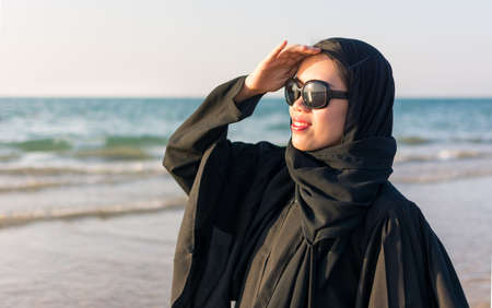 Portrait of a woman wearing abaya on the beachの写真素材