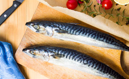 Mackerel fish with ingredients on a cutting boardの写真素材