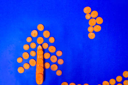 Carrot slices decoration on blue background flat layの写真素材