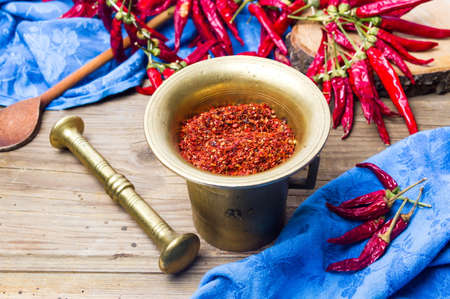 Ground and whole red pepper in a vintage mortarの写真素材