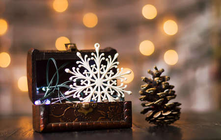 Snowflake decoration in a wooden box against festive lightsの写真素材