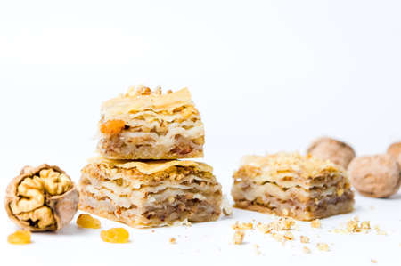 Baklava dessert with nuts and raisins on white background