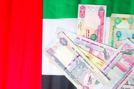 United Arab Emirates dirham banknotes on top of flagの写真素材