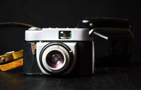 Vintage film camera against dark background. Retro technology