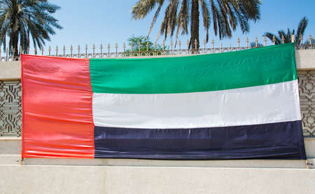 United Arab Emirates flag streatched on the stone wallの写真素材