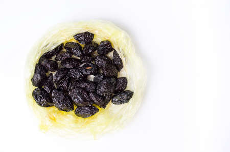 Dried plums in a bag on white backgroundの写真素材