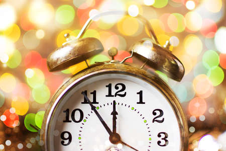 Vintage clock approaching midnight and festive Christmas lightsの写真素材