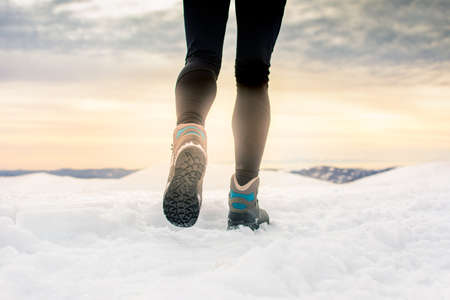 Person hiking on the mountaintop covered with snow low angle view