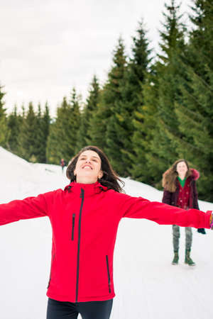 Happy girls on a hiking trip on snowy mountain path