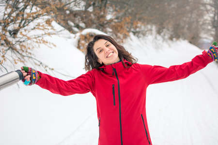 Happy female hiker walking on snowy mountain path
