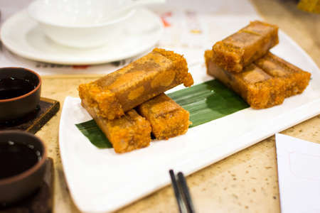 Fried coconut flavor sponge cake served on white plate on the table