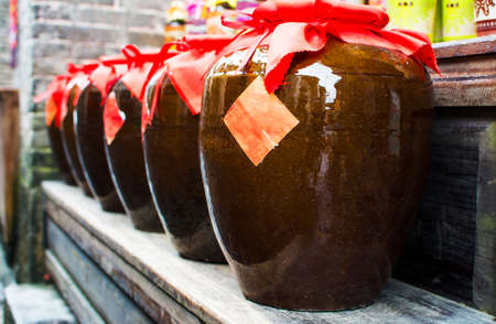 Homemade Chinese wine fermented with osmanthus flowers packed in traditional vatsの写真素材