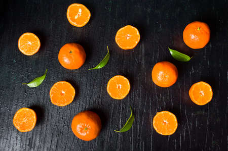 Sliced tangerine on a wooden table top view flat layの写真素材